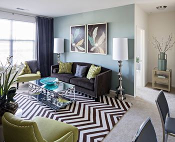 a living room with a couch and a coffee table in Reveal Hackensack apartments